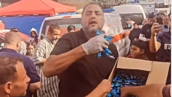 أب فلسطيني يوزع حلويات على الفلسطينييين