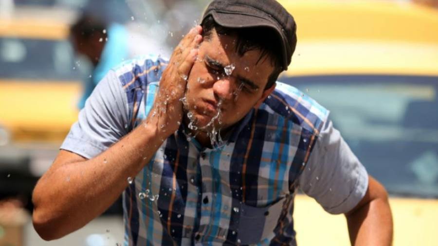 مواطن يسكب الماء على وجهه لارتفاع درجة الحرارة