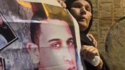 الأم ترفع صورة ابنها أمام المقابر بالدقهلية 